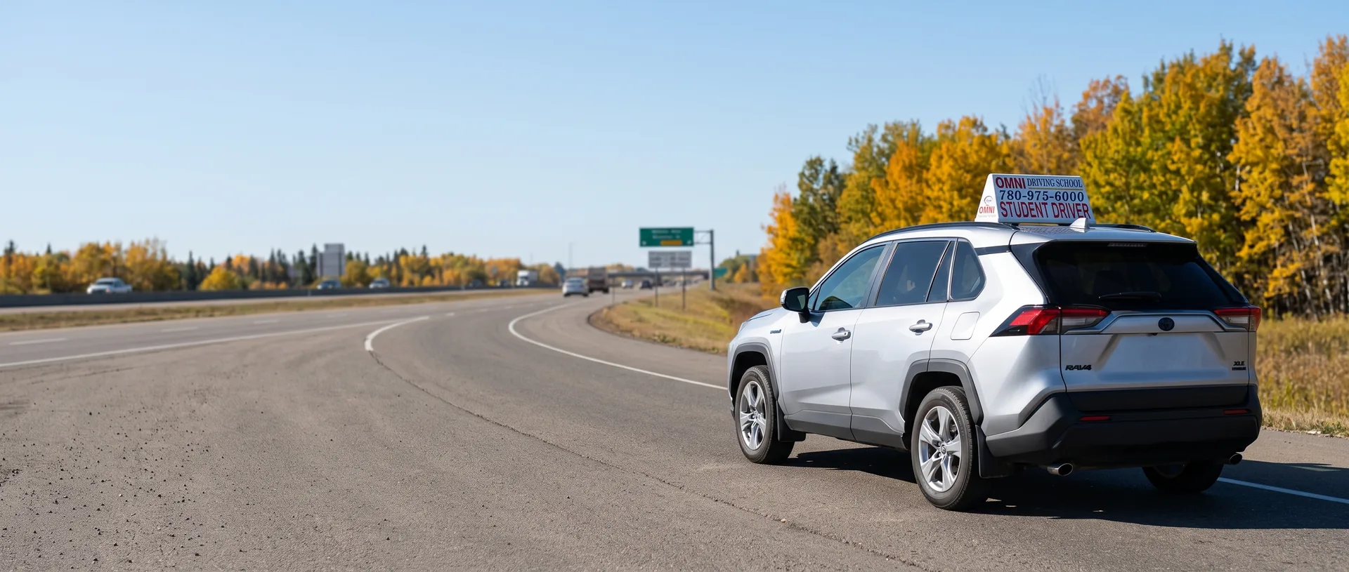 The Omni Driving School car on a highway ramp lined with autumn trees