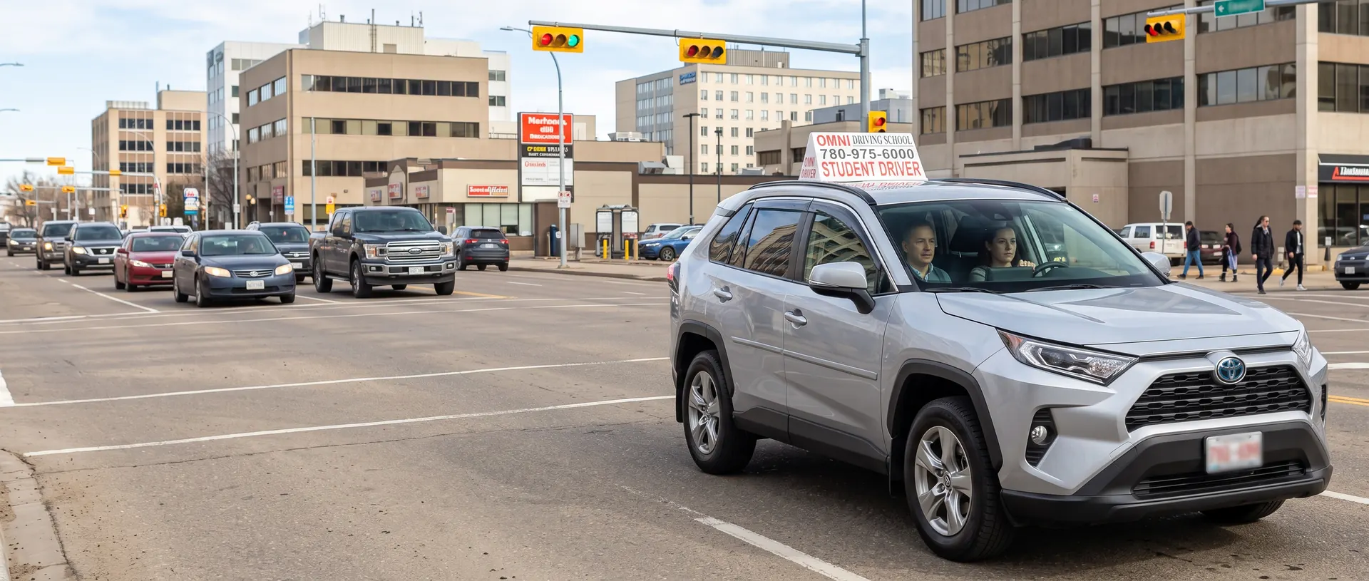 The Omni Driving School car at a busy city crossing, a student driving and the instructor beside