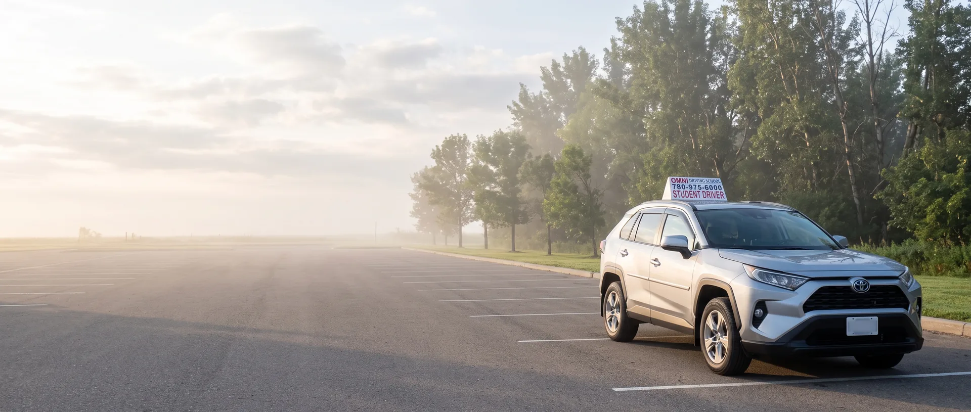 The Omni Driving School car in an empty parking lot on a misty morning